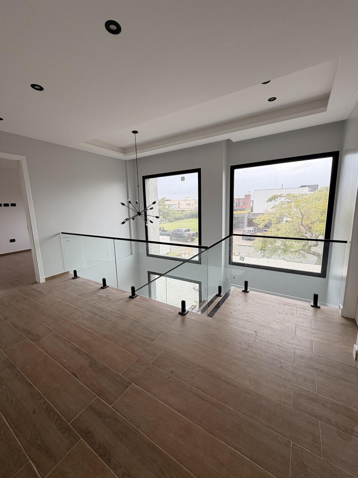Casa en Nuevo Quilmes: doble altura con baranda de vidrio y minipostes negros